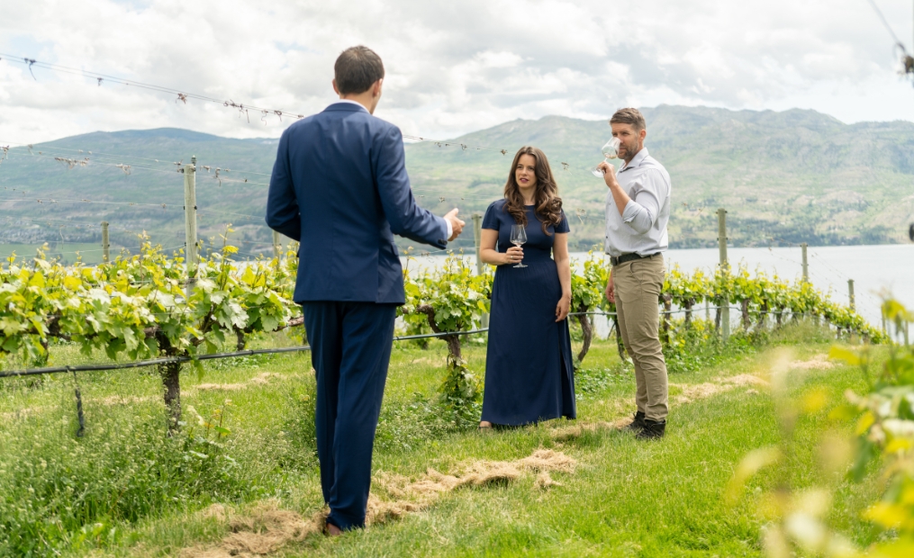 Guests enjoying a guided vineyard tour and award-winning wine tasting in the Estate Vineyards at Mission Hill Family Estate Winery, overlooking the Okanagan Valley in West Kelowna.