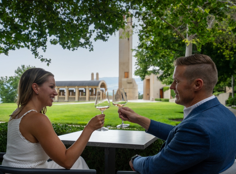 Guests enjoy a wine tasting on the grounds of Mission Hill Family Estate Winery in West Kelowna, with views of the iconic bell tower and estate architecture.